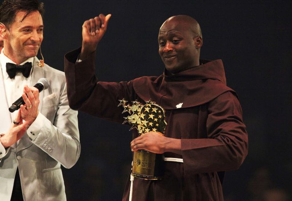 El maestro keniano Peter Tabichi, a la derecha, recibe el aplauso del actor Hugh Jackman, luego de ganar el Premio Global de Maestro en Dubai, Emiratos Árabes Unidos, el domingo 24 de marzo de 2019. Tabichi es docente de ciencias en el remoto pueblo keniano de Pwani. (AP Photo/Jon Gambrell)