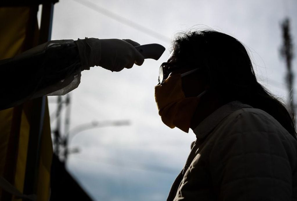 Un residente espera que le tomen la temperatura como parte de las medidas para evitar la propagación del coronavirus este viernes en un ingreso a la Villa 31 en la ciudad de Buenos Aires (Argentina). (Foto: EFE/Juan Ignacio Roncoroni)