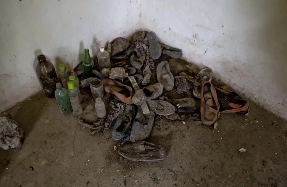 In this Oct. 6, 2014 photo, shoes and bottles are placed on a corner of a room at Monte Peloni, a former detention center during last dictatorship in Olavarria, Argentina. A hearing set for next year will uncover abuses allegedly committed against 40 othe