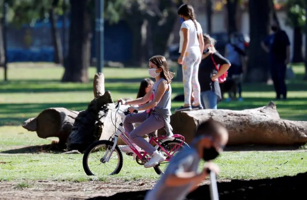 A girl wearing a face mask rides a bike in a park after restrictions were partially lifted for children in the city of Buenos Aires during the coronavirus disease (COVID-19) outbreak, Argentina May 16, 2020. REUTERS/Agustin Marcarian