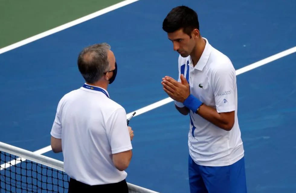 New York (United States), 07/09/2020.- Novak Djokovic of Serbia (R) talks to Head of Officiating at International Tennis Federation (ITF) Soeren Friemel after he accidentally hit a linesperson with a ball in the throat during his match against Pablo Carreno Busta of Spain on the seventh day of the US Open Tennis Championships at the USTA National Tennis Center in Flushing Meadows, New York, USA, 06 September 2020. Djokovic was defaulted from tournament. Due to the coronavirus pandemic, the US Open is being played without fans and runs from 31 August through 13 September. (Tenis, Abierto, España, Estados Unidos, Nueva York) EFE/EPA/JASON SZENES