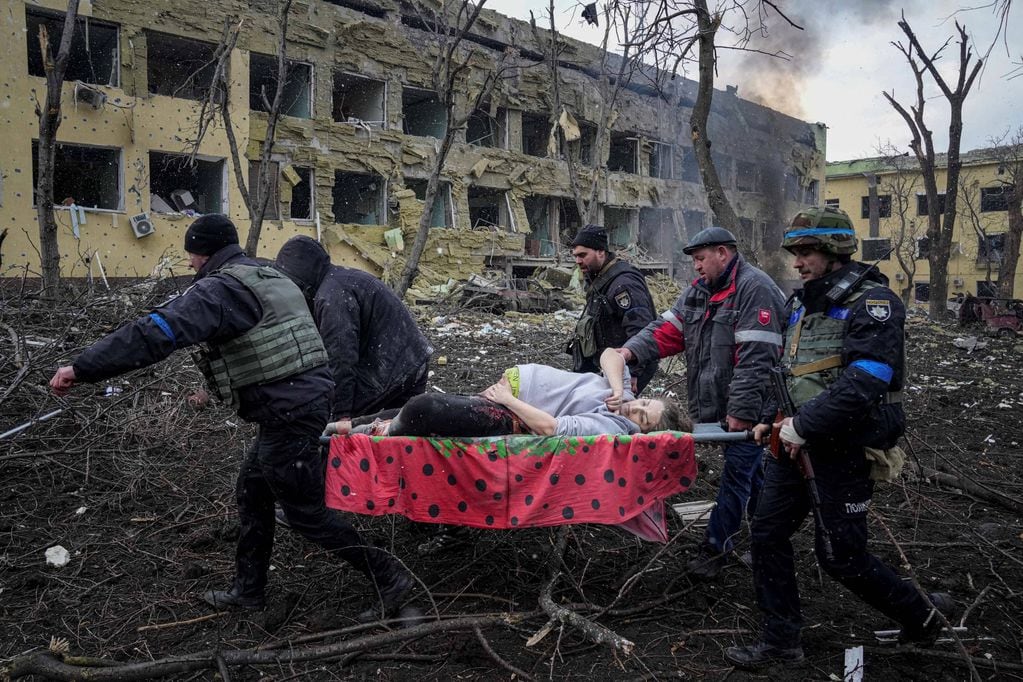 Civiles y servicio de emergencias llevan a una embarazada herida durante el bombardeo a un hospital de Mariúpol. (AP Photo / Evgeniy Maloletka)