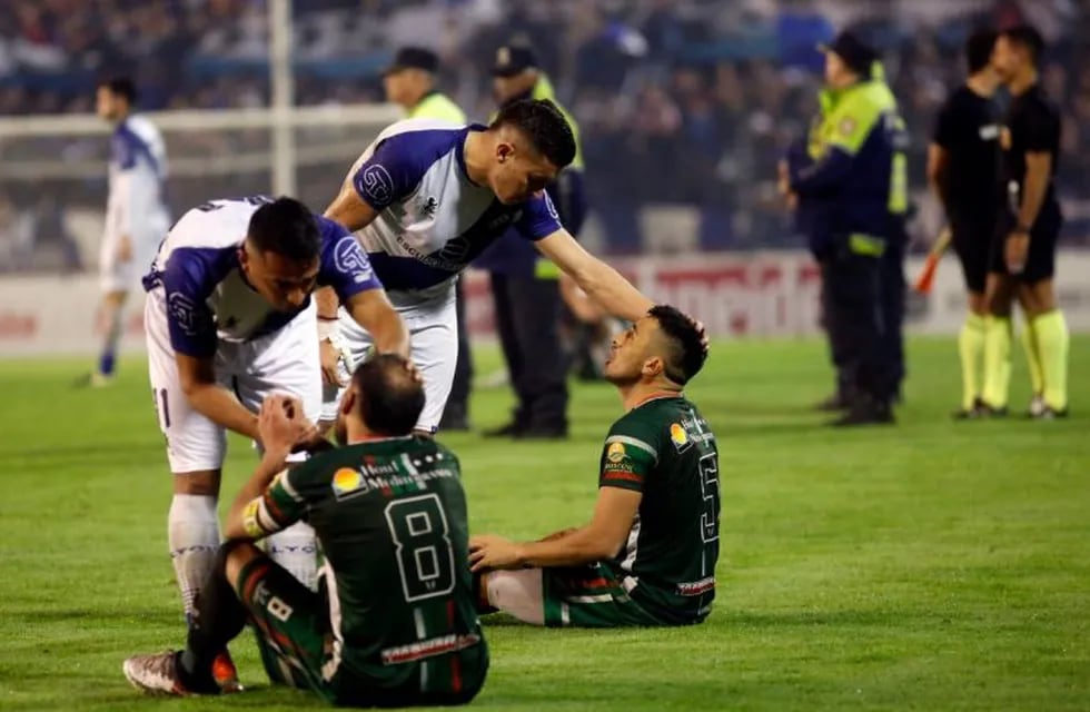 La sentada de los jugadores del equipo tucumano, previo al abandono del campo. Un escándalo.