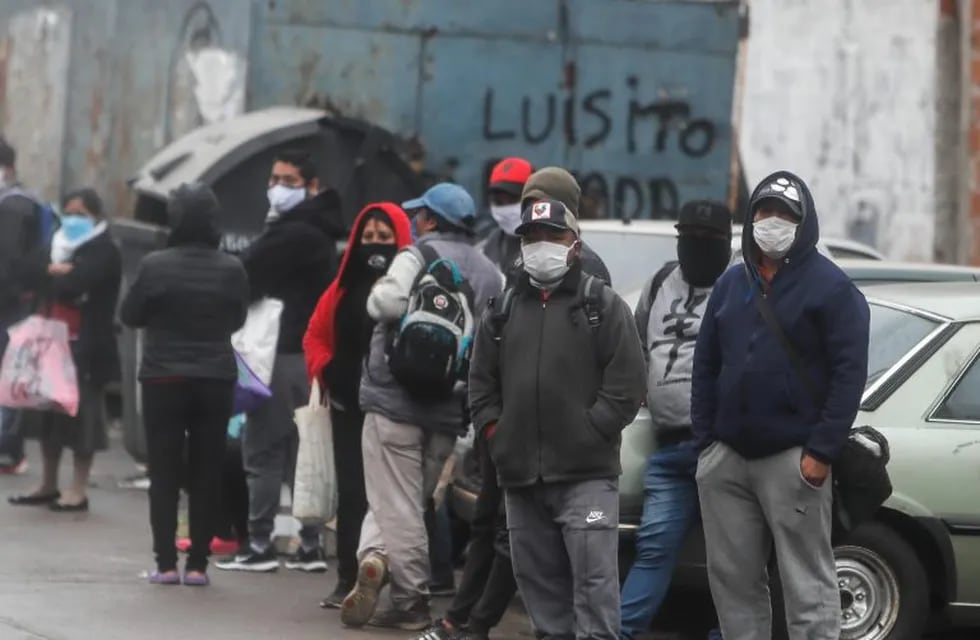 AME4761. BUENOS AIRES (ARGENTINA), 05/06/2020.- Un grupo de personas espera alimentos frente a un comedor comunitario durante la crisis del coronavirus este viernes en el barrio Padre Rodolfo Ricciardelli, anteriormente conocido como Villa 1-11-14, en la Ciudad de Buenos Aires (Argentina). EFE/Juan Ignacio Roncoroni