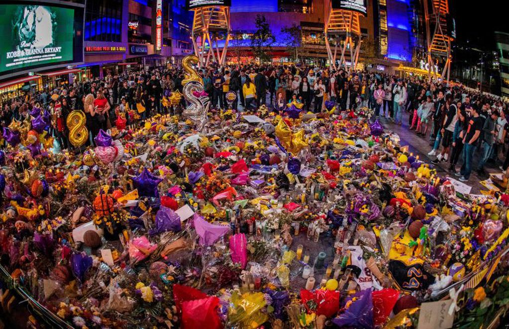 TOPSHOT - Los Angeles Lakers fans pay their respects at a Staples Center memorial to NBA legend Kobe Bryant, who was killed last weekend in a helicopter eccident, in Los Angeles, California on January 31, 2020. (Photo by Mark RALSTON / AFP)