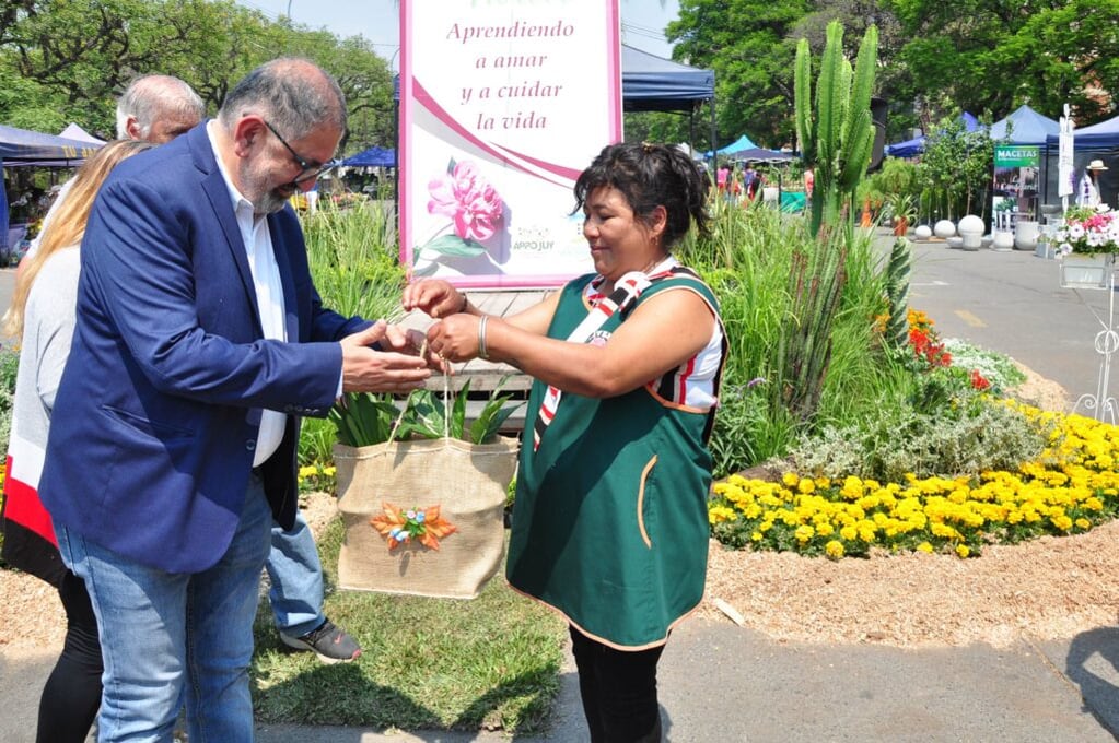 El intendente Jorge recibe de manos de una de las expositoras de “Jujuy Florece”, un obsequio que resume la temática de la muestra: plantas ornamentales.