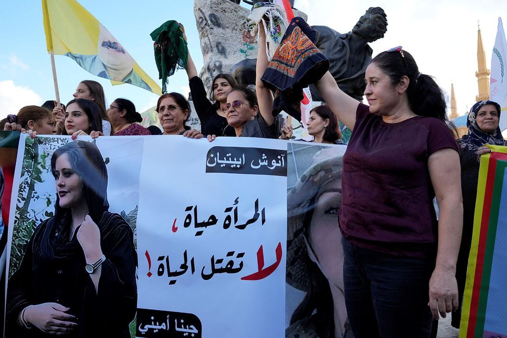 Mujeres activistas kurdas sostienen pañuelos en la cabeza y un retrato de la mujer iraní Mahsa Amini, en árabe que dice: "La mujer es vida, no maten la vida", durante una protesta contra su muerte en Irán, en la Plaza de los Mártires en Centro de Beirut. Foto AP
