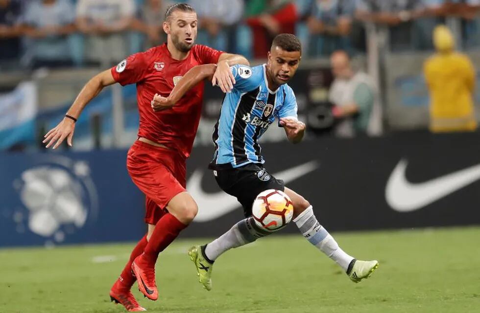 Alisson of Brazil's Gremio, right, fights for the ball with Gaston Silva of Argentina's Independiente during a Recopa Sudamericana final soccer match, in Porto Alegre, Brazil, Wednesday, Feb. 21, 2018. (AP Photo/Andre Penner)