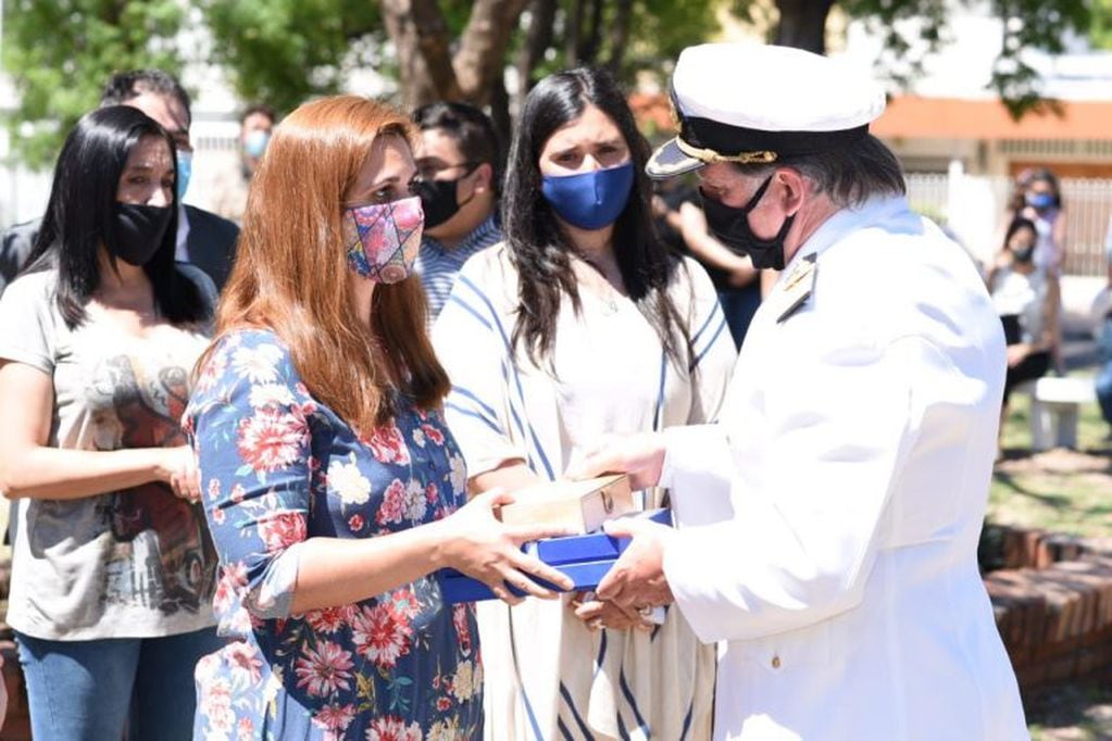 Capitán de Navío Daniel Nicola, jefe de la Delegación Naval Córdoba, entregando el Pabellón Nacional y Jinetas. a Laura Albanese.