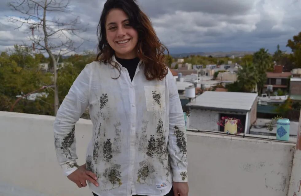 Agostina Andrada creadora del emprendimiento. Viste una camisa estampada con jarilla.