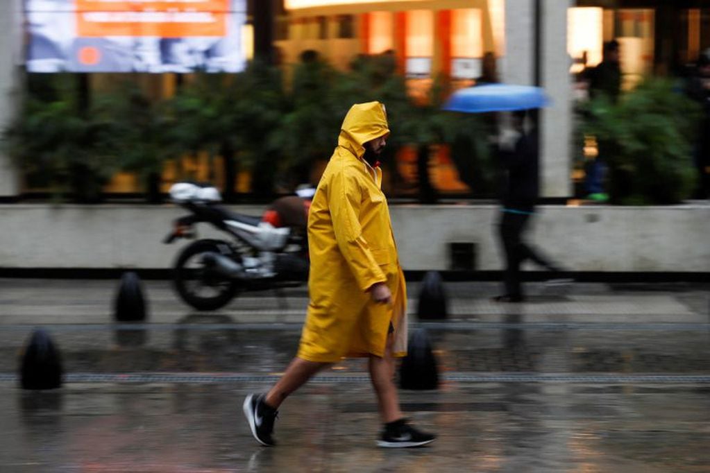 Un hombre camina durante la tormena en Buenos Aires. (Foto: EFE/David Fernández)