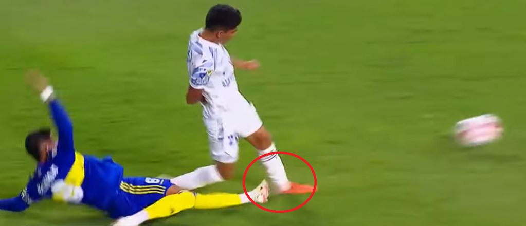 El defensor de Boca, Marcos Rojo se arroja desde atrás y está por derribar, dentro del área, al jugador Salomón Rodríguez de Godoy Cruz.