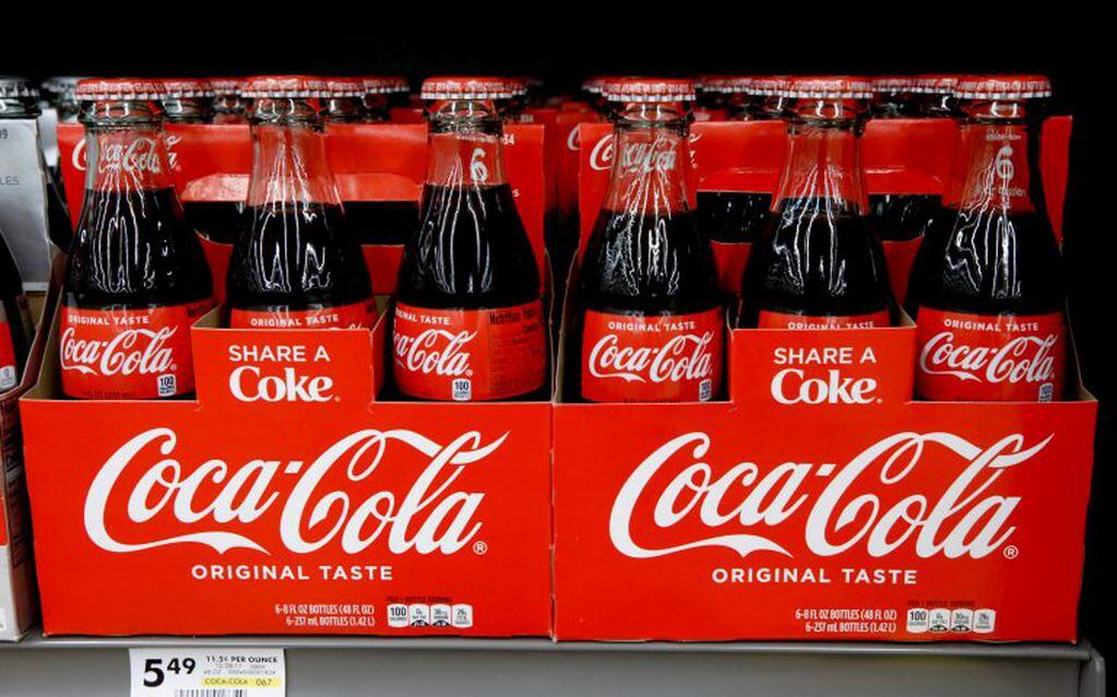 FILE--In this Aug. 8, 2018, file photo, bottles of Coca Cola sit on a shelf in a market in Pittsburgh. The Coca-Cola Company says that it's "closely watching" the growth of the use of a non-psychoactive element of cannabis in wellness drinks. (AP Photo/Gene J. Puskar, file)   Coca estudia lanzar una bebida terapeutica de marihuana negocio de la marihuana medicinal