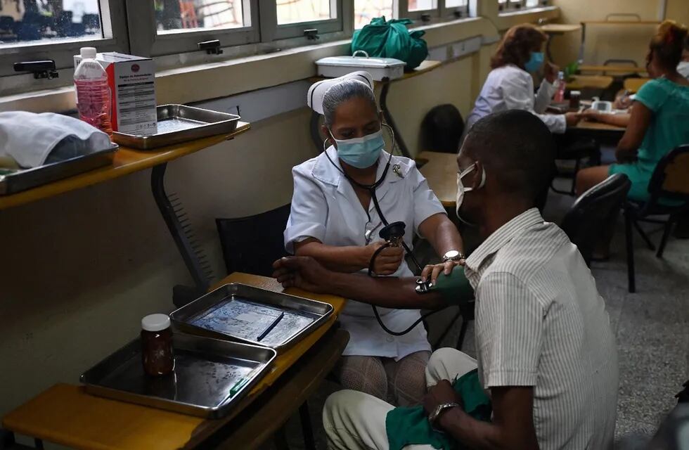 Una enfermera revisa la presión arterial de un trabajador de la salud antes de inocularlo con la segunda dosis de la vacuna cubana candidata Abdala contra COVID-19.