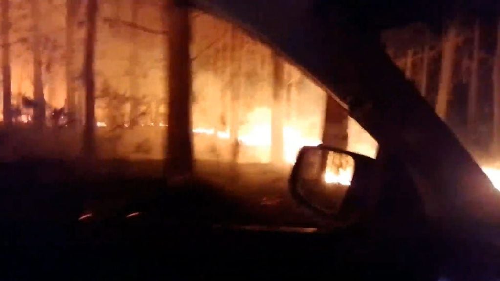 Bomberos luchan por apagar un incendio forestal en Mártires.