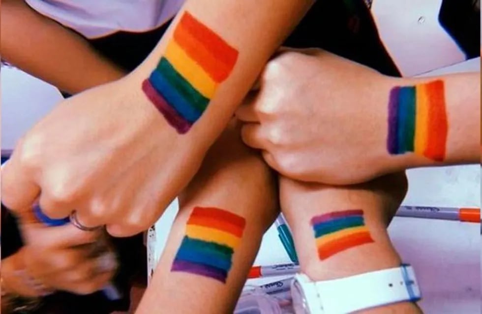 Jóvenes con banderas LGBT pintadas en sus manos (Web)