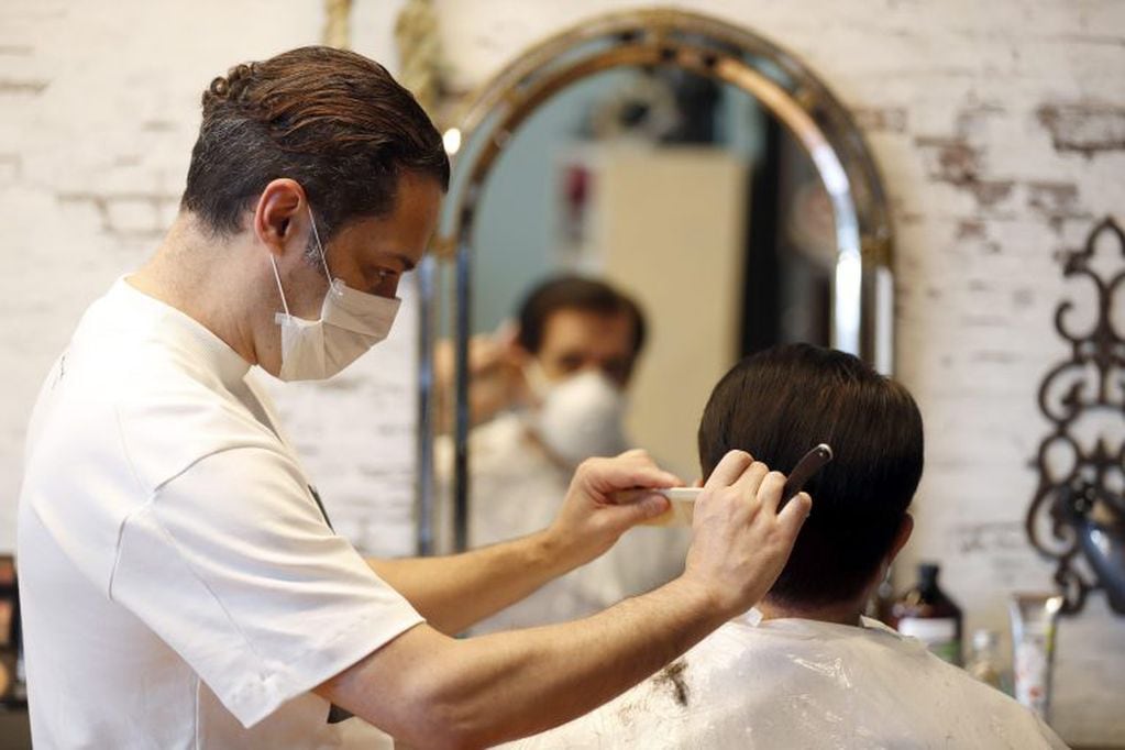 Un peluquero atiende a un cliente en Bilbao, España. (EFE)