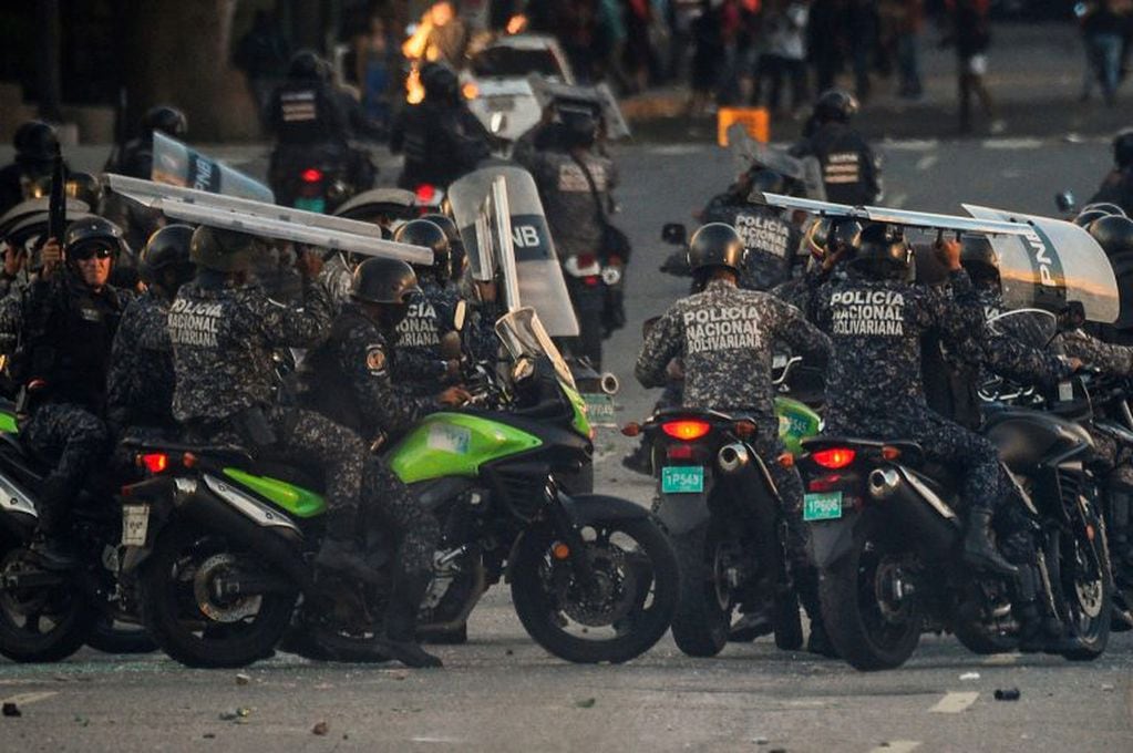 La policía nacional confronta a manifestantes en contra de Maduro. (AFP)