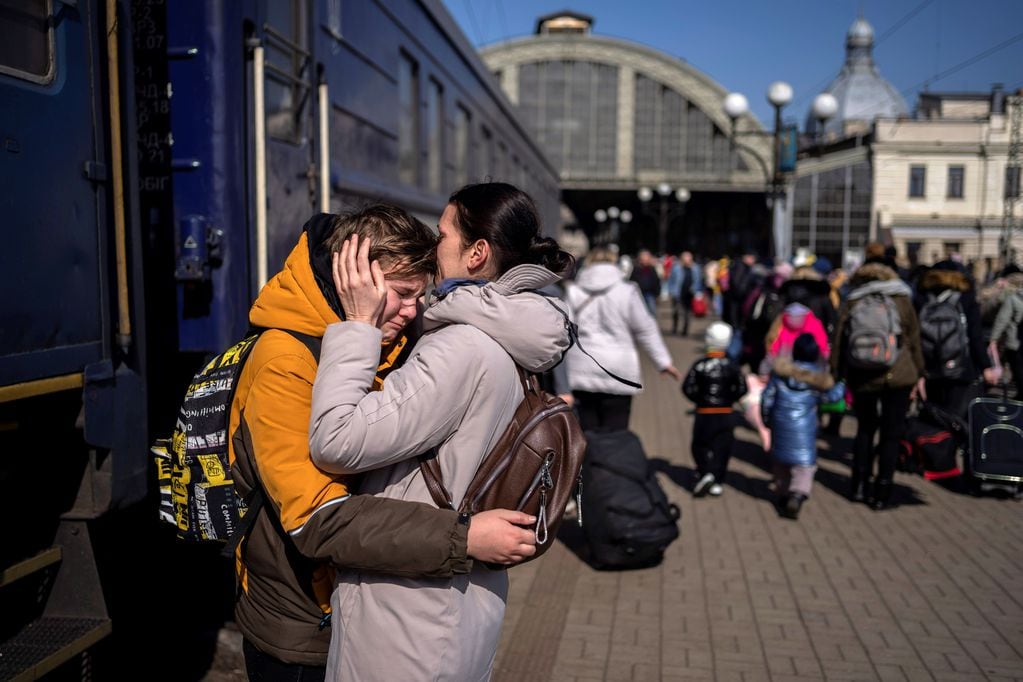 Una madre abraza a su hijo que escapó de la ciudad sitiada de Mariupol y llegó a la estación de tren de Lviv, en el oeste de Ucrania. (AP)