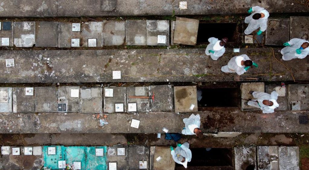 Una de las imágenes más sensibles, cuando empleados del cementerio de Nova Cachoeirinha, el segundo más grande de Sao Paulo (Brasil), retiraban los huesos de las tumbas antiguas para hacer sitio a los nuevos muertos por Covid-19. (Foto: DPA)