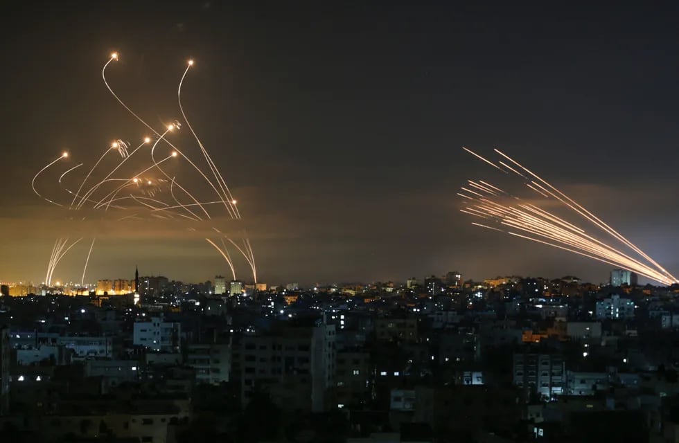Cohetes en el cielo nocturno disparados hacia Israel desde Beit Lahia en el norte de la Franja de Gaza el 14 de mayo de 2021. - Israel atacó Gaza y desplegó tropas adicionales en la frontera mientras los palestinos disparaban bombardeos de cohetes, con el número de muertos en el enclave. en el cuarto día de conflicto subiendo a más de 100.