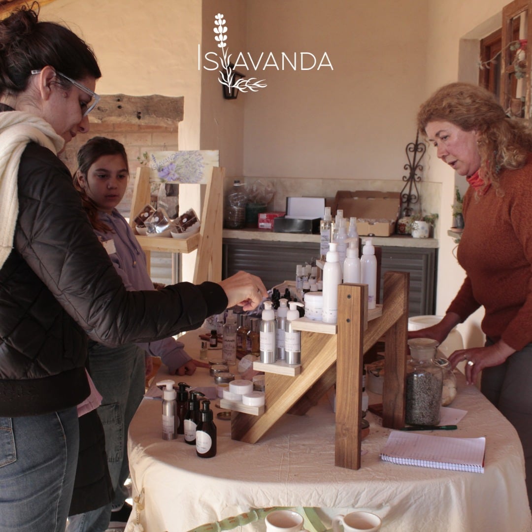 Mirna Islas junto a visitantes, en el salón de ventas del campo.