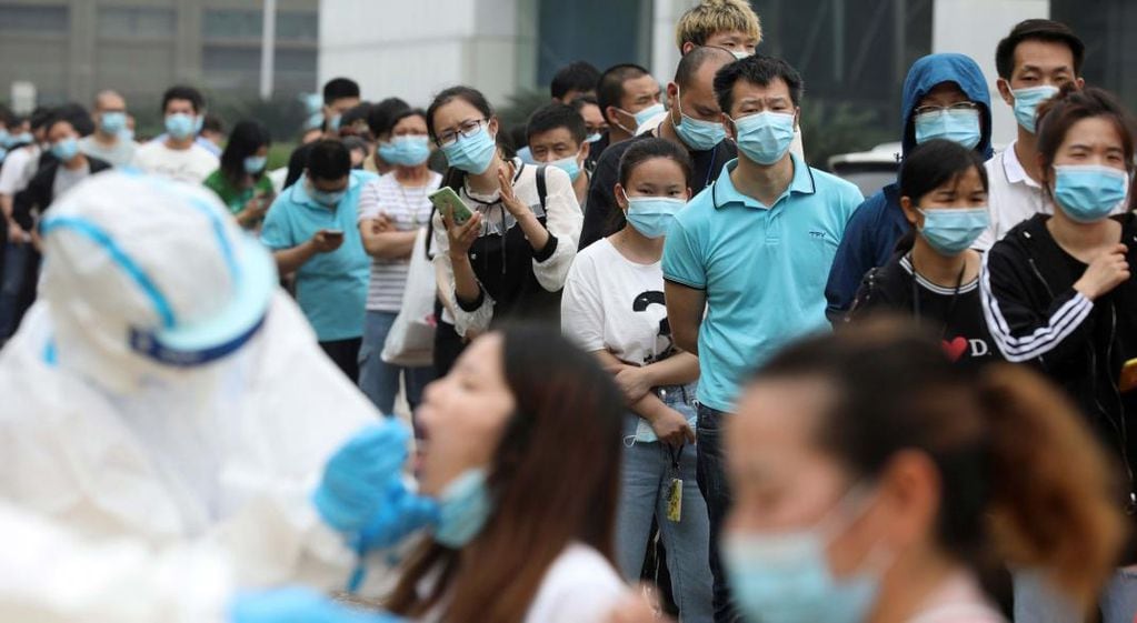 Las personas hacen fila para las pruebas de coronavirus en una gran fábrica en Wuhan (AP/Archivo).