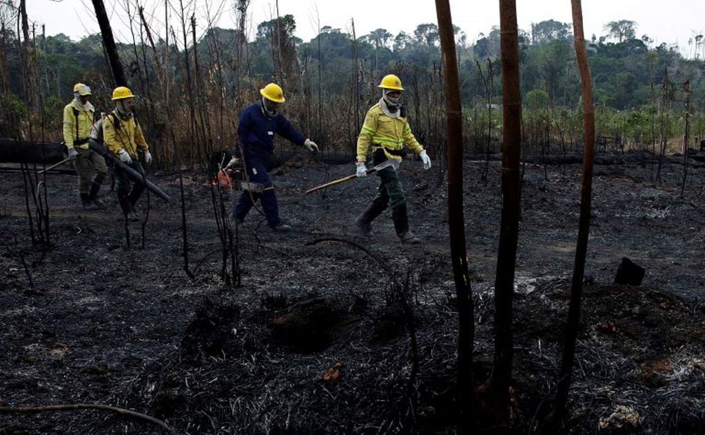 Bomberos caminan por las hectáreas quemadas cerca del camino a el Bosque Nacional Jacunda en Villa Nueva Samuel, Porto Velho, Brasil. Foto: AP/Eraldo Peres.