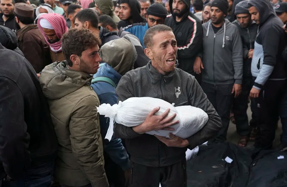 Un palestino sostiene el cuerpo de un niño muerto en los bombardeos israelíes en la Franja de Gaza, en Deir al Balah, el 23 de febrero de 2024.