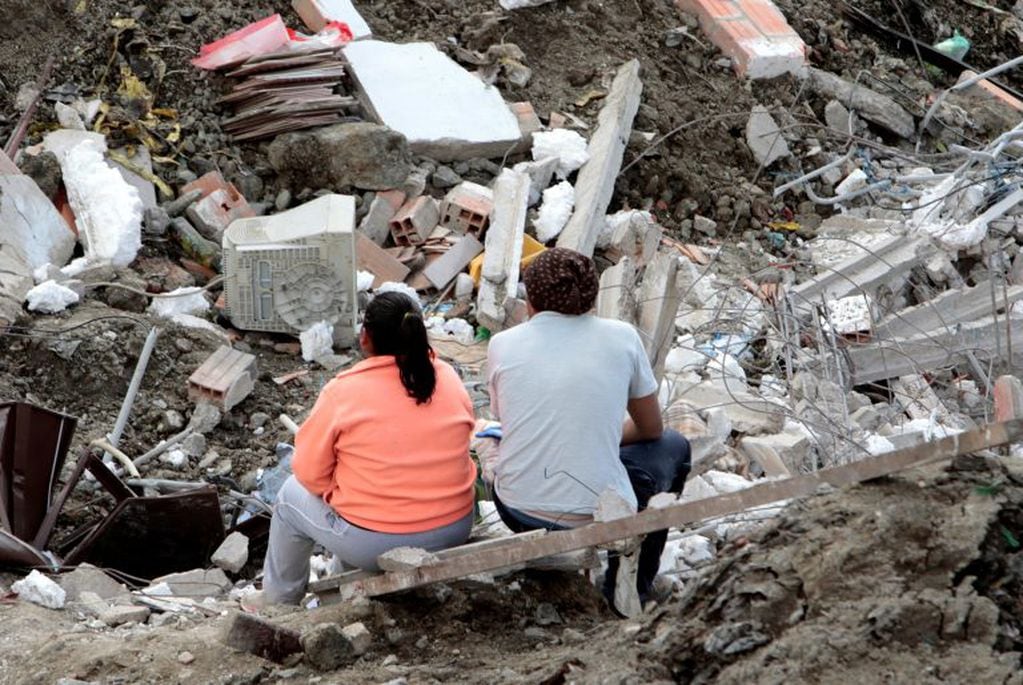 Una pareja contempla los restos de lo que fue su vivienda, que fuera destruida por el deslizamiento en el terreno, que antes era un basural, en La Paz, Bolivia. REUTERS/Manuel Claure