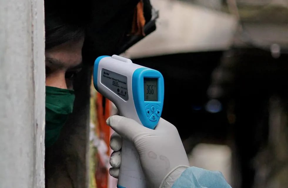 17 June 2020, India, Mumbai: A health worker checks the body temperature of a woman suring a door to door Coronavirus (Covid-19) test in a slum in Mumbai. Photo: Ashish Vaishnav/SOPA Images via ZUMA Wire/dpa