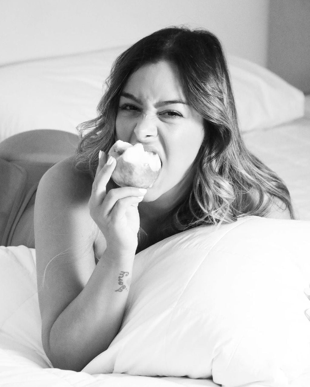 Larissa Riquelme mordió una manzana mientras lucía lencería desde la cama.