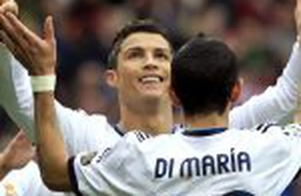 MADRID, 27/01/2013.- El delantero portuguu00e9s del Real Madrid, Cristiano Ronaldo (c), celebra con su compau00f1ero, el argentino u00c1ngel Di María (d), su segundo gol conseguido frente al Getafe, el tercero del partido, durante el encuentro correspondiente a la vi