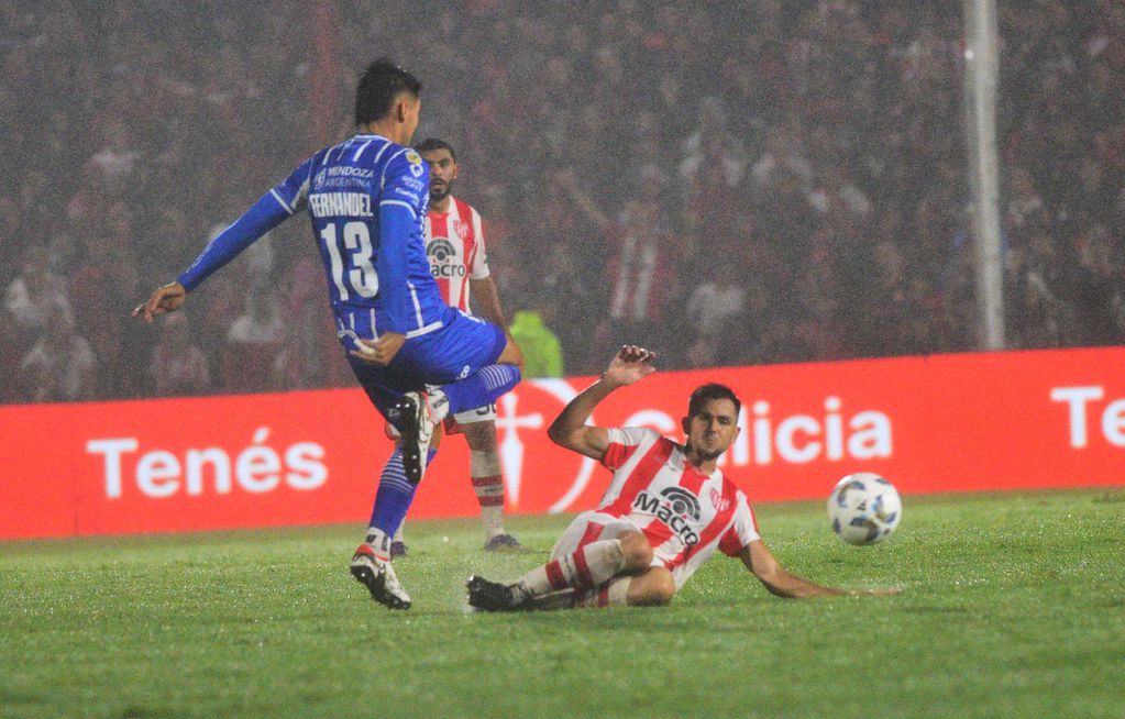 Bochi va al piso en busca de una pelota en medio de la lluvia en Alta Córdoba (Foto: Javier Ferreyra).