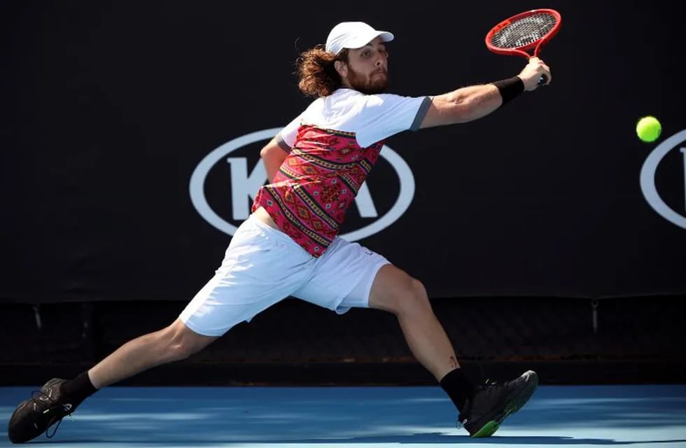 Marco Trungelliti of Argentina makes a backhand return to Tennys Sandgren of the U.S. during their first round singles match at the Australian Open tennis championship in Melbourne, Australia, Tuesday, Jan. 21, 2020. (AP Photo/Andy Brownbill)