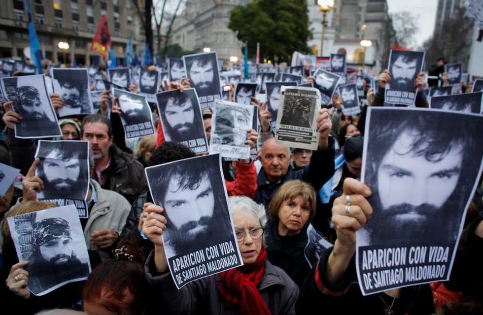 FILE - In this Aug. 11, 2017 file photo, people hold up posters with an image of missing activist Santiago Maldonado, during a demonstration at Plaza de Mayo, in Buenos Aires, Argentina. Social and political organizations have called for a demonstration on Friday, Sept. 1, demanding the government find Maldonado, last seen on Aug. 1, when police evicted a group of Mapuche Indians from lands owned by Italian clothing company Benetton. (AP Photo/Victor R. Caivano, File)