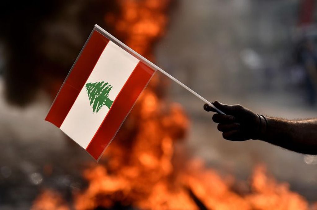 Un manifestante con una bandera de Líbano durante protestas en las calles de Beirut (EFE/EPA/WAEL HAMZEH)