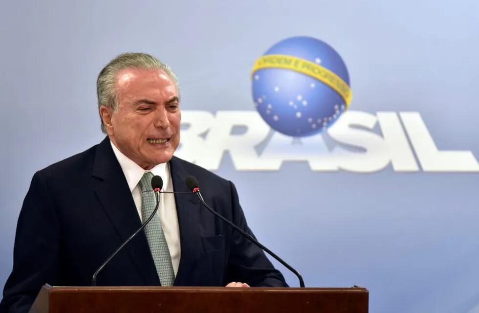 In this Thursday, May 18, 2017 photo, Brazil's President Michel Temer says he will fight allegations that he endorsed the paying of hush money to an ex-lawmaker jailed for corruption, during a national address at the Planalto presidential palace in Brasilia, Brazil. Temer rejected calls for his resignation. (AP Photo/Ricardo Botelho)