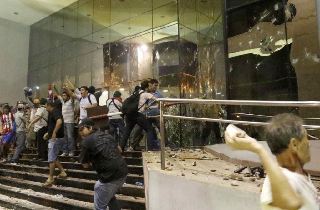 ASU47. ASUNCIÓN (PARAGUAY), 31/03/2017.- Manifestantes atacan hoy, viernes 31 de marzo de 2017, la sede del Congreso Nacional en Asunción (Paraguay). Grupos de manifestantes y agentes de la Policía Nacional mantienen enfrentamientos frente al edificio del