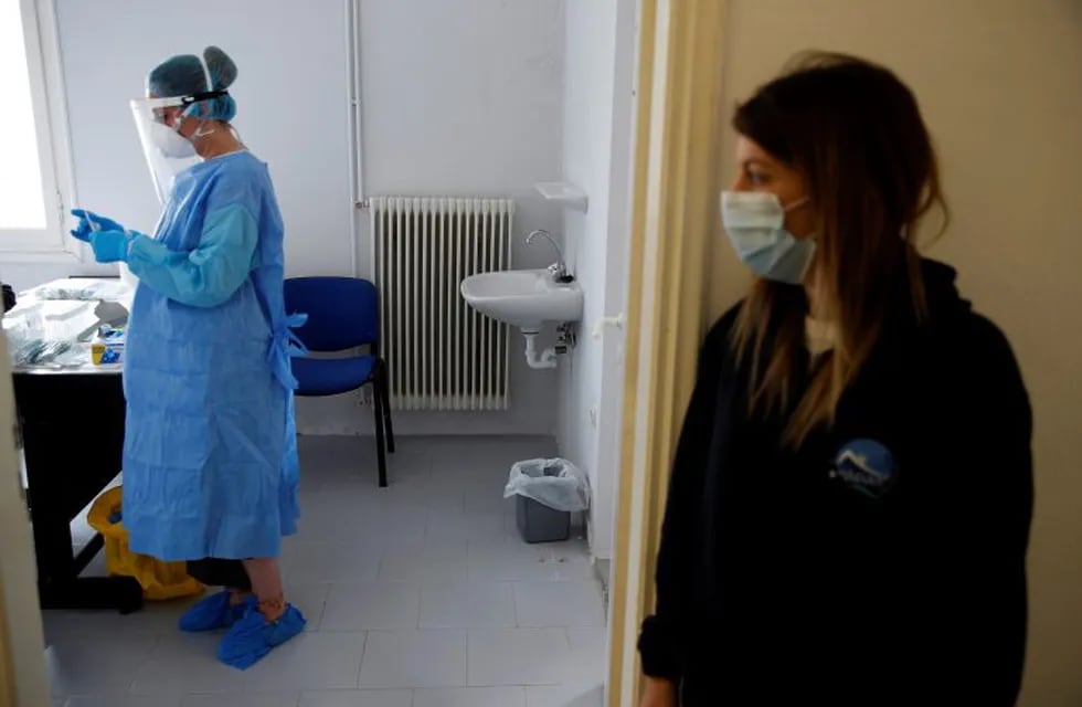 A doctor conducts tests for the new coronavirus as a nurse looks on the Aegean Sea island of Milos, Greece, on Tuesday, May 26, 2020. EODY the National Health Organization and the non-for-profit Organization Symplefsi, organized a two-day mission to perform COVID-19 tests including vulnerable residents on four remote Greek islands. Greece restarted regular ferry services to its islands Monday, and cafes and restaurants were also back open for business as the country accelerated efforts to salvage its tourism season. (AP Photo/Thanassis Stavrakis)