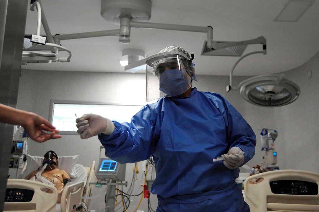 Trabajadores de la salud atienden a un paciente con covid-19 (Foto: Andres Larrovere / AFP)
