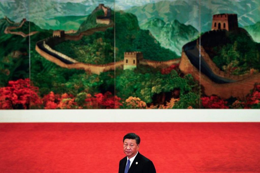 Xi Jinping frente a un gran mural de la Muralla China