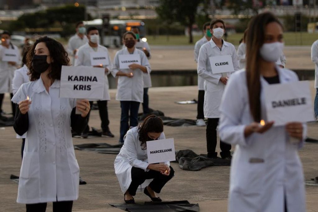 Un grupo de enfermeras y enfermeros realizan un acto simbólico en el Día Internacional de la Enfermería, en la Esplanada dos Ministérios, en honor a los colegas que han muerto a causa de la COVID-19, este martes en Brasilia (Brasil). (Foto: EFE/ Joédson Alves)