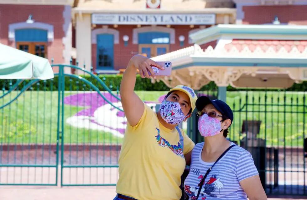 Maria Delgadillo takes a selfie with her mother Rosa Torres at the entrance to Disneyland on the reopening day of the Downtown Disney District on its reopening day in Anaheim, Calif., Thursday, July 9, 2020. (Jeff Gritchen/The Orange County Register via AP)