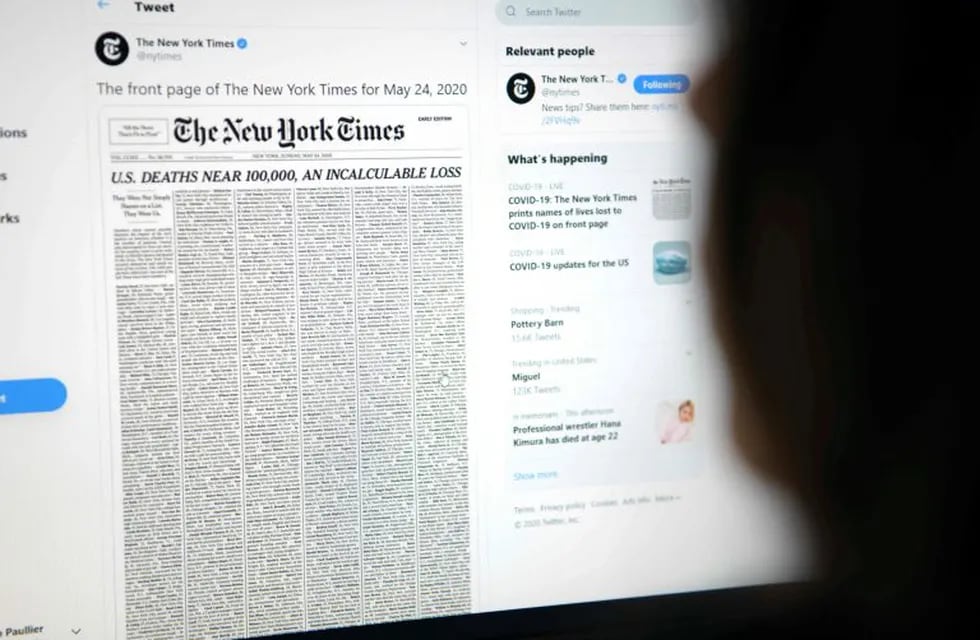 This picture taken on May 23, 2020, in Los Angeles, California, shows a woman looking at a computer screen with a tweet by the New York Times newspaper account showing the early edition front page of May 24, 2020, with a list of 1,000 names printed on it, that represents 1% of the lives lost due to the novel coronavirus pandemic, COVID-19, in the US. (Photo by Agustin PAULLIER / AFP)