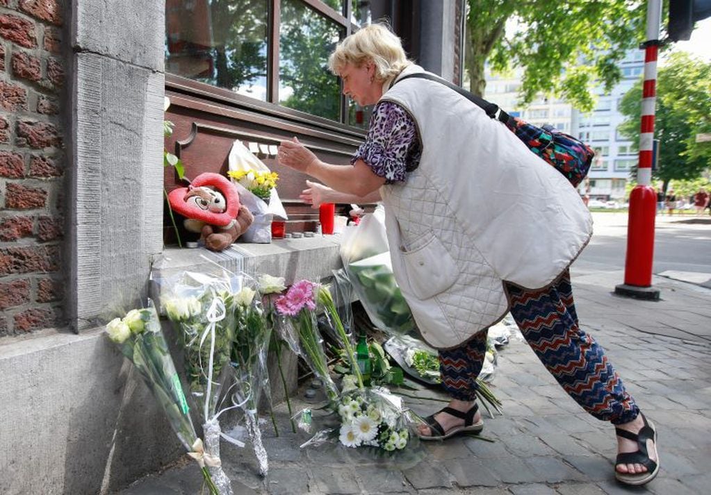 Varias personas colocan flores como homenaje a las víctimas del tiroteo de ayer ante el Cafe 'Les Augustins', de Lieja, Bélgica. EFE/ Stephanie Lecocq