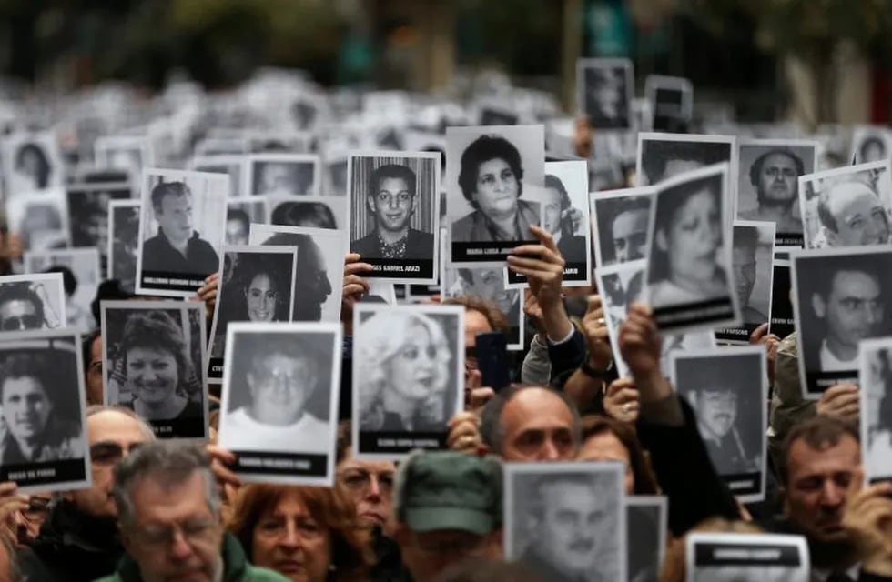 People hold images of the victims of the 1994 bombing attack on the Argentine Israeli Mutual Association (AMIA) community centre, marking the 25th anniversary of the attack, in Buenos Aires, Argentina, July 18, 2019. REUTERS/Agustin Marcarian
