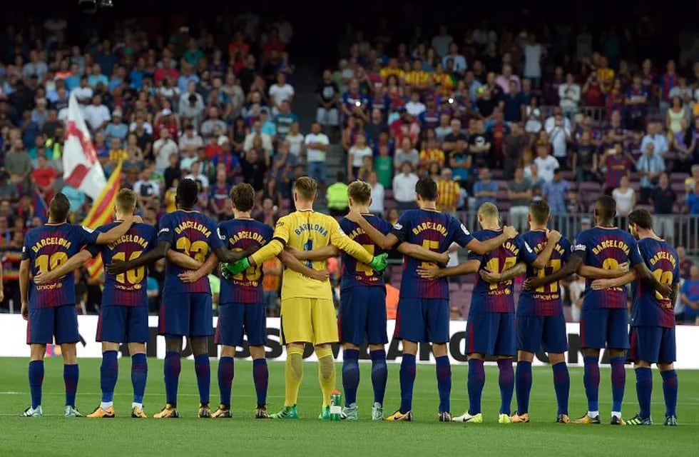 Barcelona's football players observe a minute of silence as they wear jerseys reading \