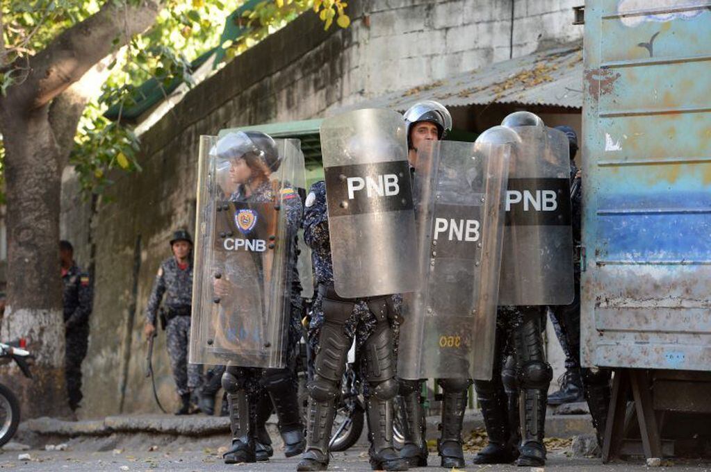 Riot police clash with anti-government demonstrators in the neighborhood of Los Mecedores, in Caracas, on January 21, 2019. - A group of soldiers rose up against Venezuela's President Nicolas Maduro at a command post in northern Caracas on Monday, but were quickly arrested after posting an appeal for public support in a video, the government said. (Photo by Federico Parra / AFP)
