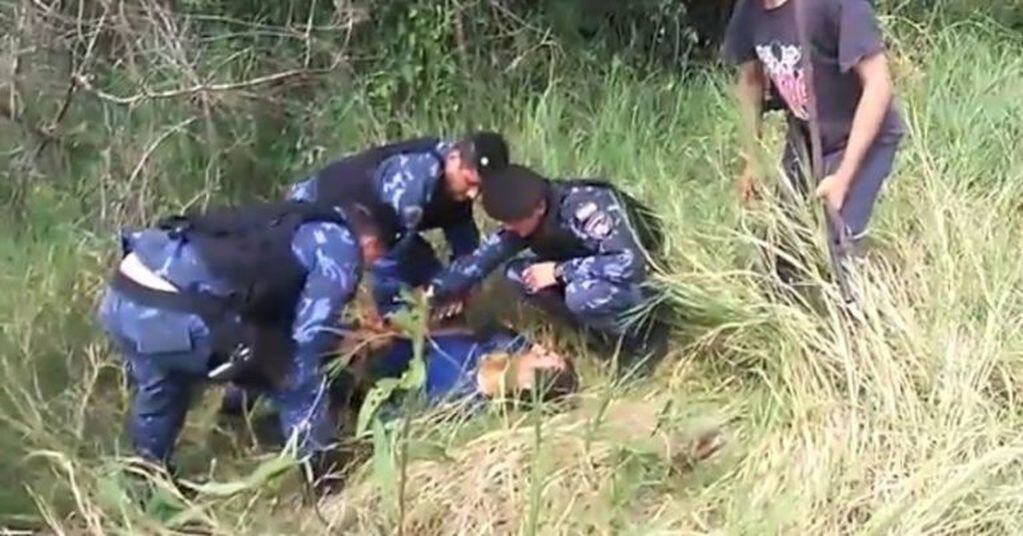 Valdir “Cuerero” Prestes Barbosa estaba oculto en una zona rural. Los policías lo atan sobre una tabla. Ya estaba herido.